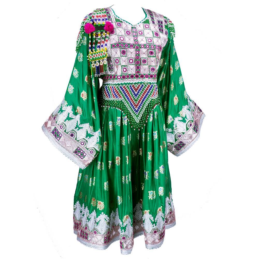 Contemporary incarnation of traditional Afghani dress. In emerald green with gold jacquard flowers and with silver bullion and intricate beadwork. Heavily embroidered with inset mirrored discs. Unlined and weighty. A modern work of a classic beauty.