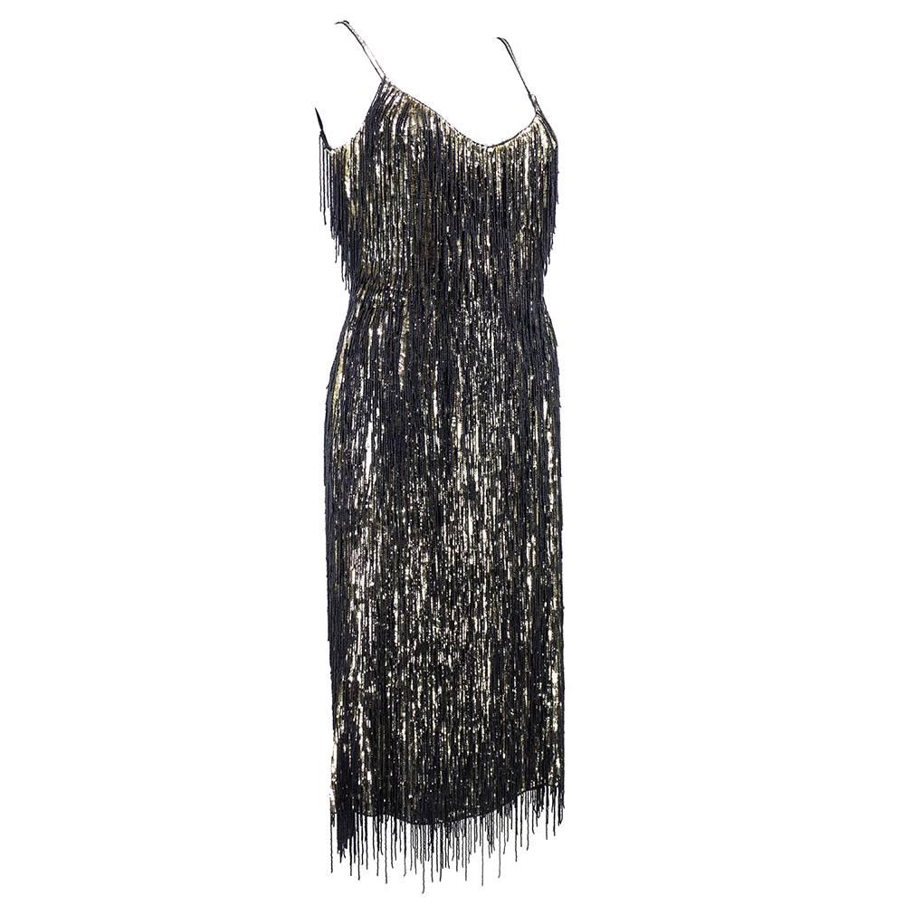 Current cocktail creation inspired by the 1920s by Escada. Gold sequins on black chiffon and completely covered in black beaded fringe. Body con silhouette with spaghetti straps. Fully lined in silk.  Ready to dance till dawn.  Looks and feels