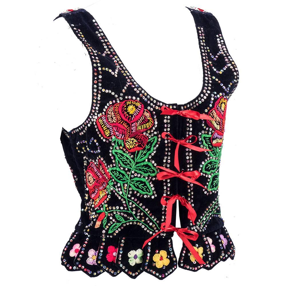 Beautiful example of ethnic workmanship. Most likely Polish black velvet vest with lovely floral hand embroidery and embellished with multi-colored sequins. Lace up front with satin ribbon. Boned at front with petalled peplum.  Beautiful work of art.