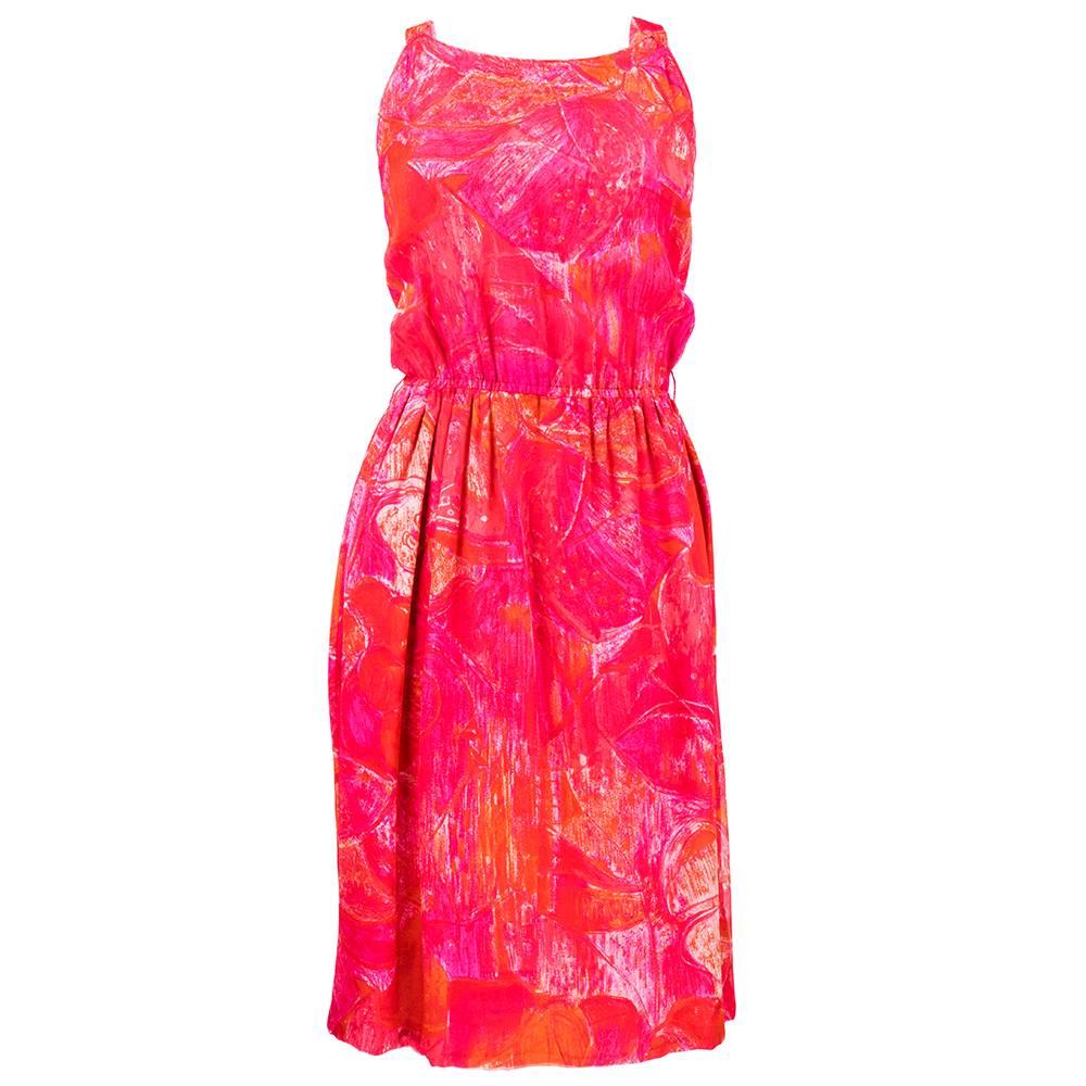 Vividly printed tropical floral silk chiffon dress from Pierre Cardin comes with a matching cape that attaches invisibly to the dress straps with a hook and eye. Print is a hot pink and orange painterly tiki inspired floral. Dress has a scoop neck