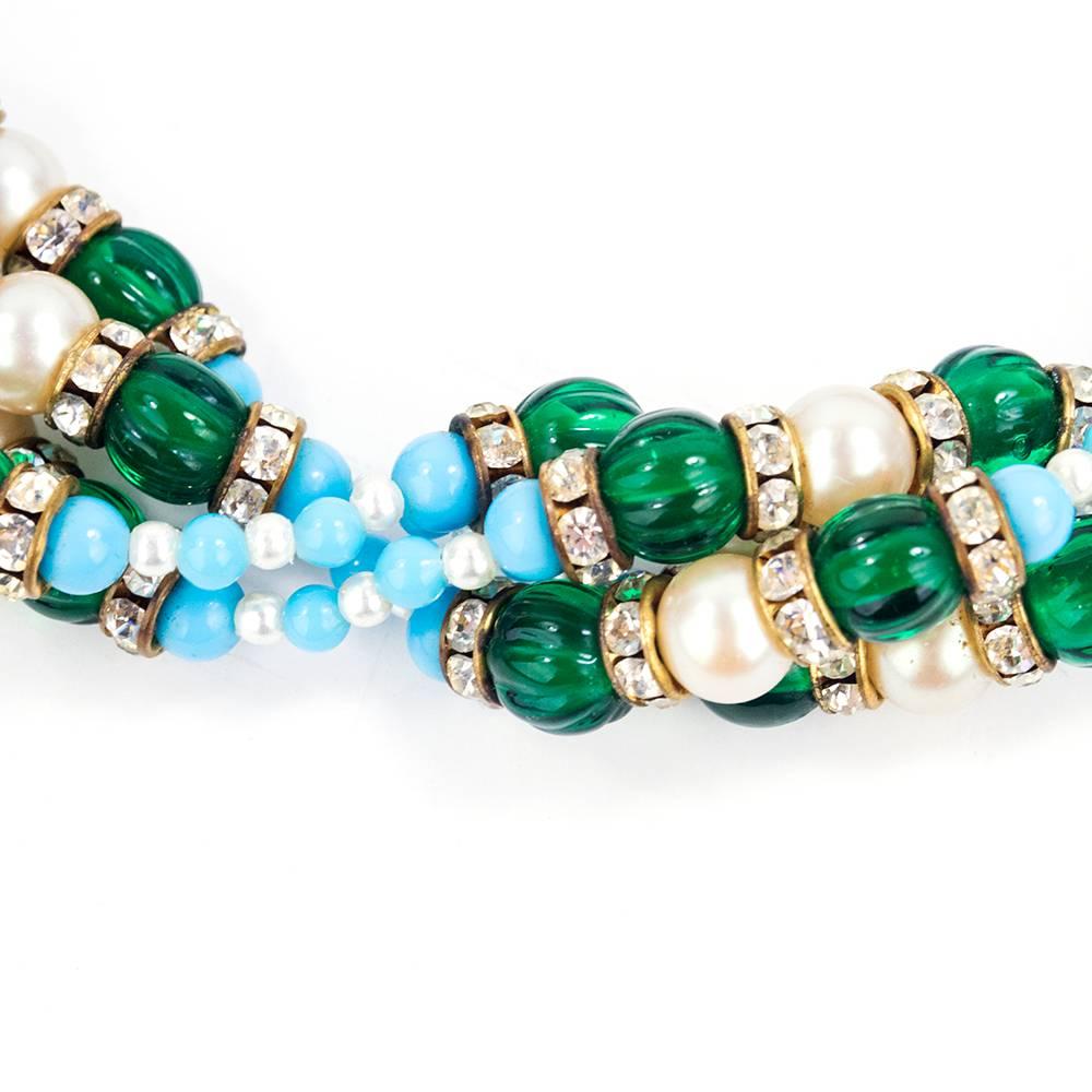 Elegant cocktail necklace by Kenneth Jay Lane circa 1960s.  Multiple strands of turquoise and emerald green colored beads interspersed with faux pearls and rhinestone rondelles. Large clasp in green enameled gold tone metal inset with rhinestones