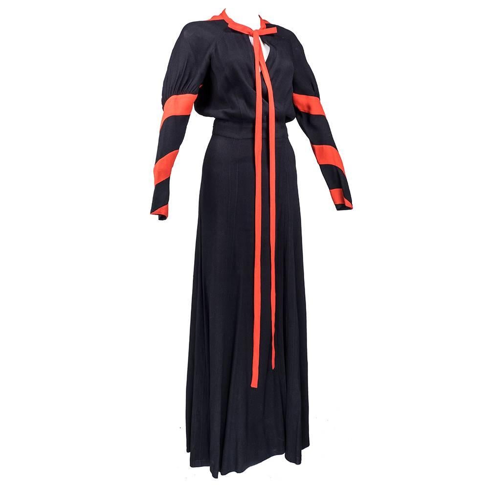 Simple and seductive 1970s does 1930s full length dress by Ossie Clark. Done in designer's signature moss crepe. Wrap style with self tie at waist. All black - trimmed in tomato red with spiraling stripe down fitted sleeve. 