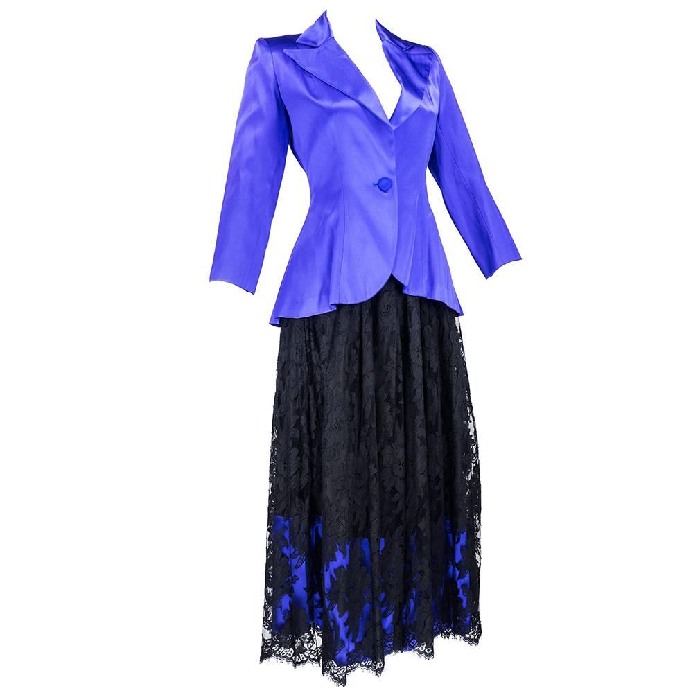 Adorable two piece ensemble circa 1990s from Patrick Kelly. Purple satin ultra fitted blazer and full skirt of black lace underlaid  with matching purple satin. 

Skirt-
Waist: 24 inches
Length: 34 inches