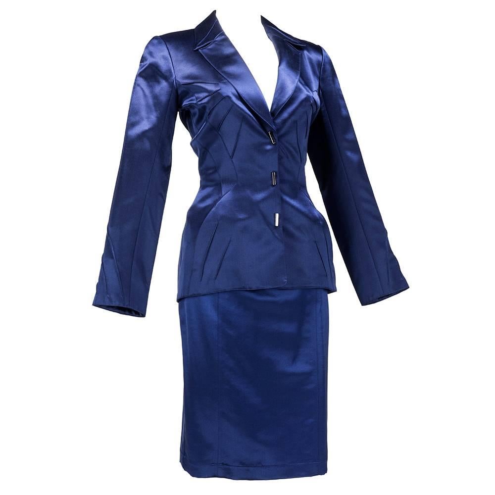 From Thierry Mugler - one of his iconic extreme tailored suit circa 1990s. In midnight blue. Pinched waist jacket with strong shoulders and tucking detail and snap closures. Slash pockets at  hips. Matching snug pencil skirt.  Modern and classic and