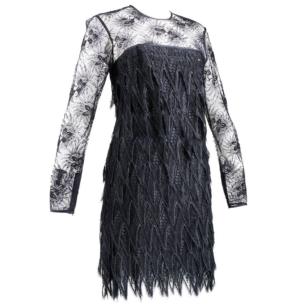 Elegant example of evening attire by the late great James Galanos. Black chantilly and other lace make up this sheath style, long sleeve cocktail dress. Tiers of zig zag cut lace create a serrated hem.  Sheer at bodice and then fully lined. Zips up