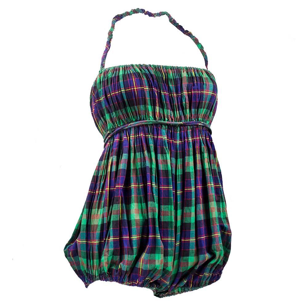 One of Claire McCardell's most iconic looks -  a cotton romper in blue and green plaid. Elasticized halter strap with empire elasticized waist. Attached wrap around tie for versatility in looks.  Diaper; style bottom with elasticized leg holes. From