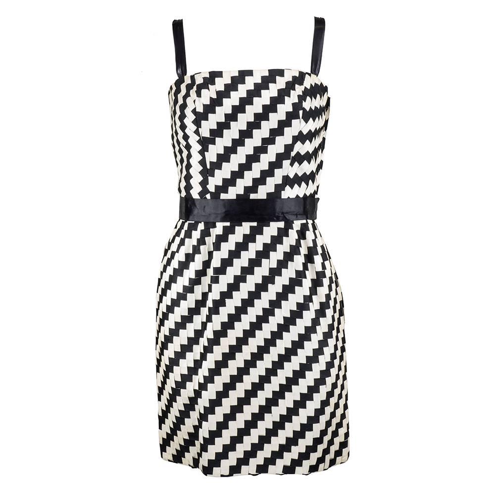 Striking, circa 1960's two piece ensemble from Italian designer Roberto Capucci, includes a cocktail dress with matching jacket, both crafted from graphically interlacing black and white ribbons. Cocktail dress is accented with black waistband and