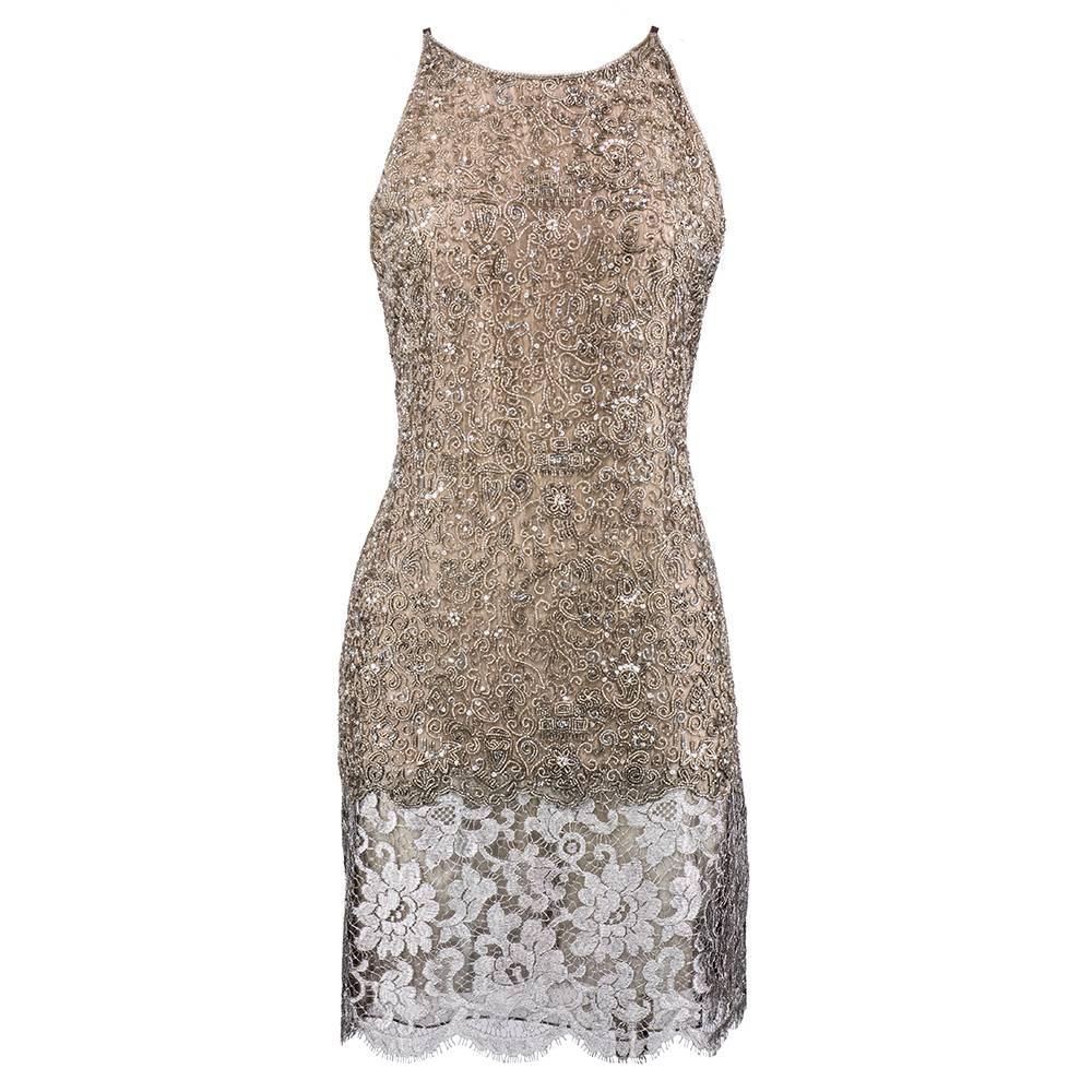 A gorgeous party dress from Genny, featuring dense paisley and floral motif beadwork with rhinestone details, and a silver metallic lace skirt. The silhouette is almost a modern nod to the 1920s flapper dresses. A matching silver lace jacket