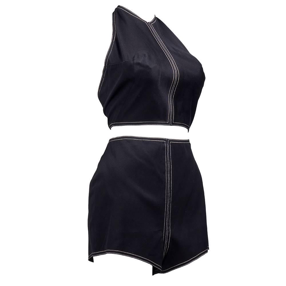 2 piece playsuit in black cotton with contrasting white stitching by iconic American designer Claire McCardell. Signature brass hook and eye closure down side. Button closure at neck and back of halter. Fully lined.

Shorts: 
Waist: 24 inches
Hip: