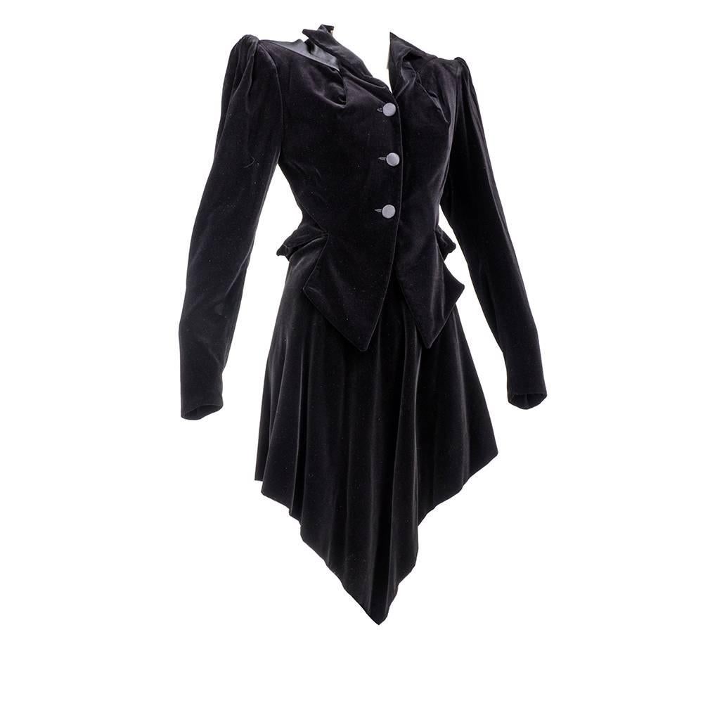 Black velveteen equestrian style jacket with Victorian influence and matching handkerchief skirt. The tailored jacket is fitted at the waist with a peplum. The collar is formed from bust darts, using signature Westwood draping techniques. Slight