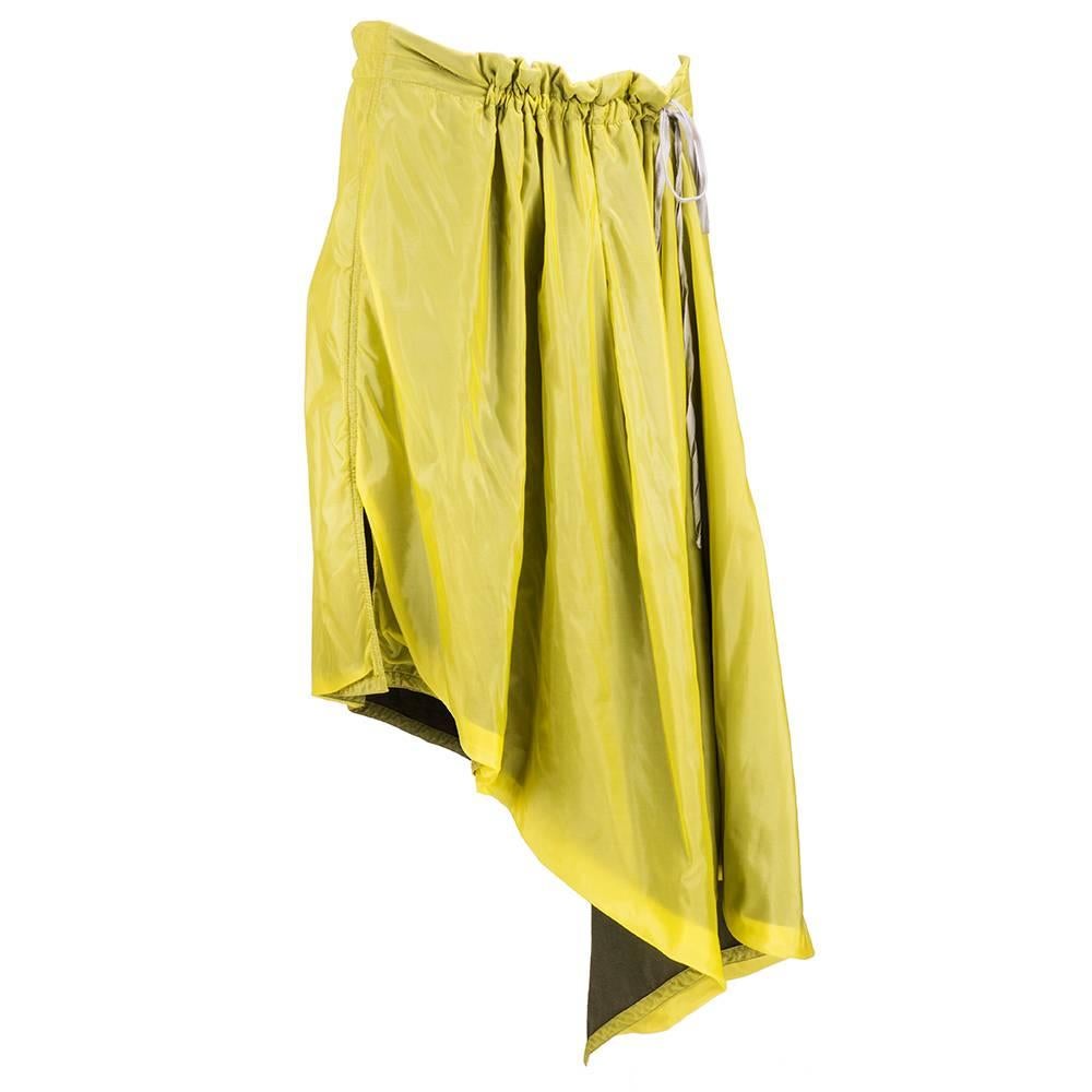 Wonderful avant garde design by famed Belgian designer Ann Demeulemeester. Asymmetrically cut skirt in yellow nylon backed with olive colored jersey. Single drawstring gathers waist at section.

Waist: 26-36 inches