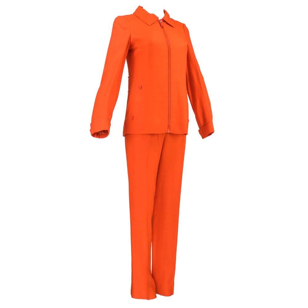 Iconic space age design by famed French designer Andre Courreges, for his Hyperbole label. 2 piece bright orange acetate blend raw linen look fabric.  Shirt jacket zips down front with oversized zipper with slash pockets at hip. Paired with high