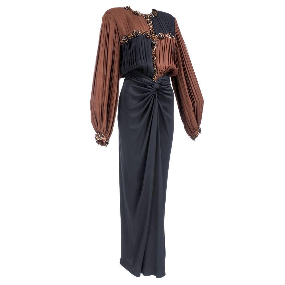 Elegant and dramatic gown circa 1980s attributed to James Galanos. Brown and black chiffon pleated at bodice encrusted with iridescent beads. Silk sarong style full length skirt. Buttons and zips down back - partially lined. Strong, padded