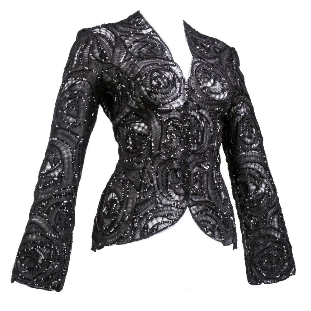 Ingeniously designed jacket by Italian master Giorgio Armani. Black tulle cut into swirls with shirring, surrounded by tiny, iridescent sequins. Sheer and unlined with scalloped edges.  Snap closures up front.  A beautiful confection!