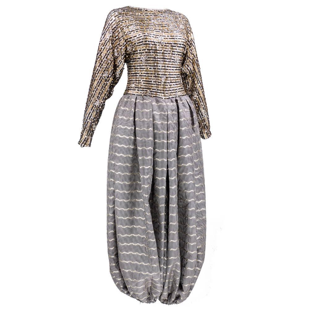 Incredible evening jumpsuit by the great James Galanos circa 1980s. Metallic - top in black sheer mesh lined in silk - striped and sprinkled with gold and silver sequins. With low, low sexy back.  Pants are super wide ballon legged with elasticized