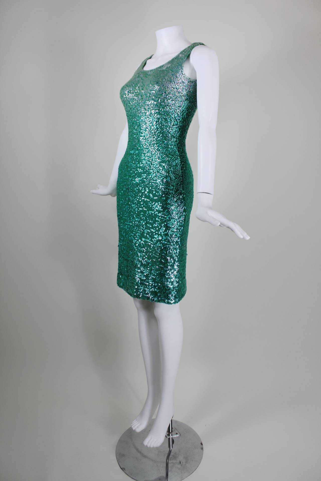 A fabulous knit dress from the 1960s, covered in graduating shades of green sequins. The dress is unlined and zips in the back. Slinky silhouette.