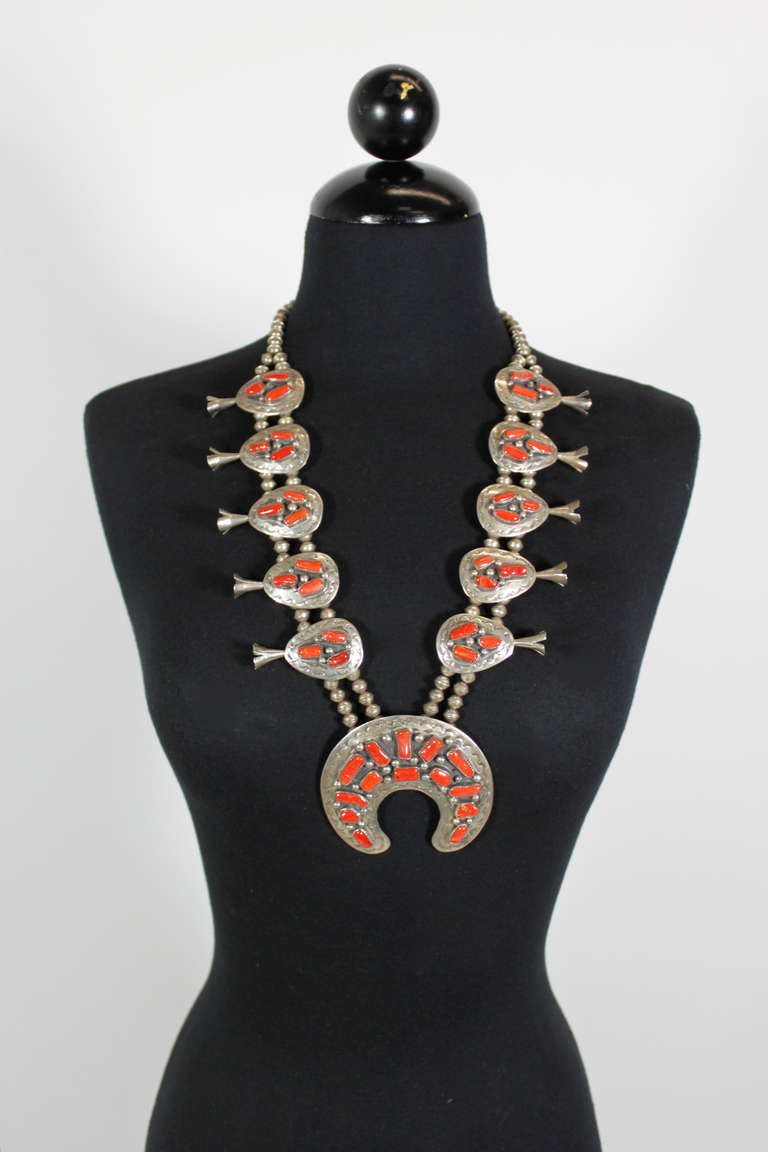 Classic Navajo squash blossom necklace with natural coral set in stamped sterling silver.

Meausrements--
Largest Squash: 3 inches x 3.5 inches
Smaller Squash: 2 inches x 1.25 inches
Necklace hangs 12 inches
Total Length: 26 inches