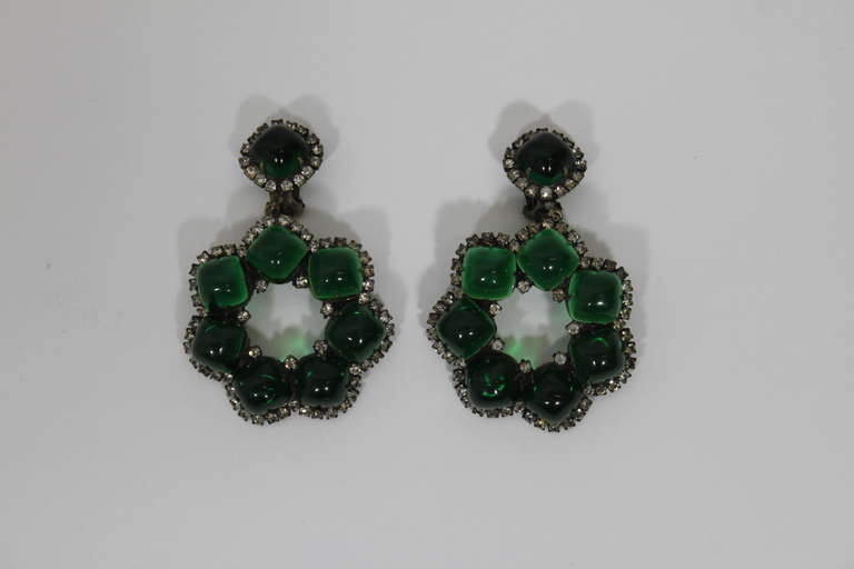 Classic oversized cocktail earrings by Kenneth Jay Lane. Emerald green floral motif. Surrounded by rhinestones. Clip-on. 