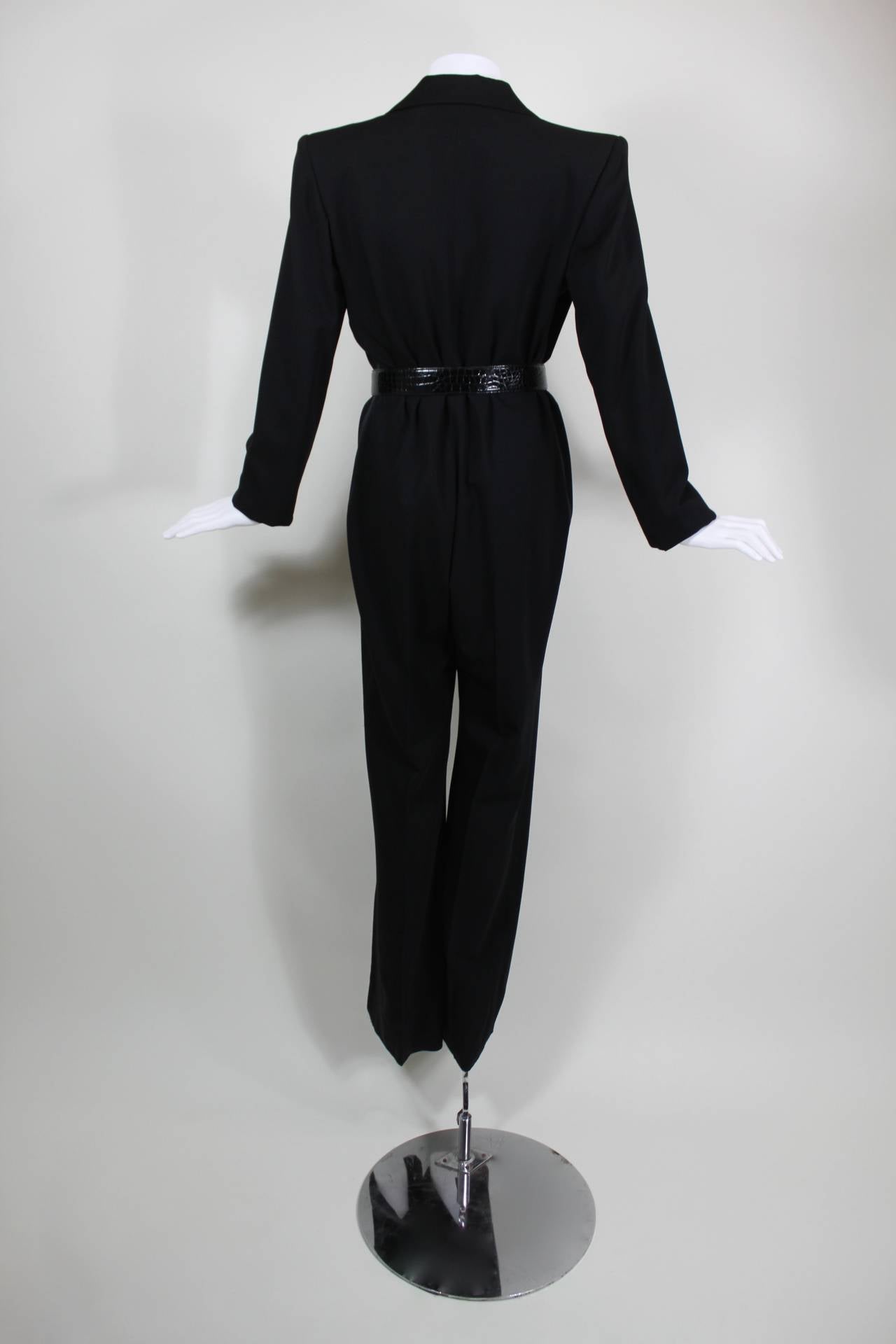 A classic wool gabardine tuxedo jumpsuit from Yves Saint Laurent. Features a deep-V tuxedo cut with satin lapels. Jumpsuit buttons in front. Fully lined.

Measurements--
Bust: 38 inches
Waist: 32 inches
Hip: up to 40 inches
Inseam: 34