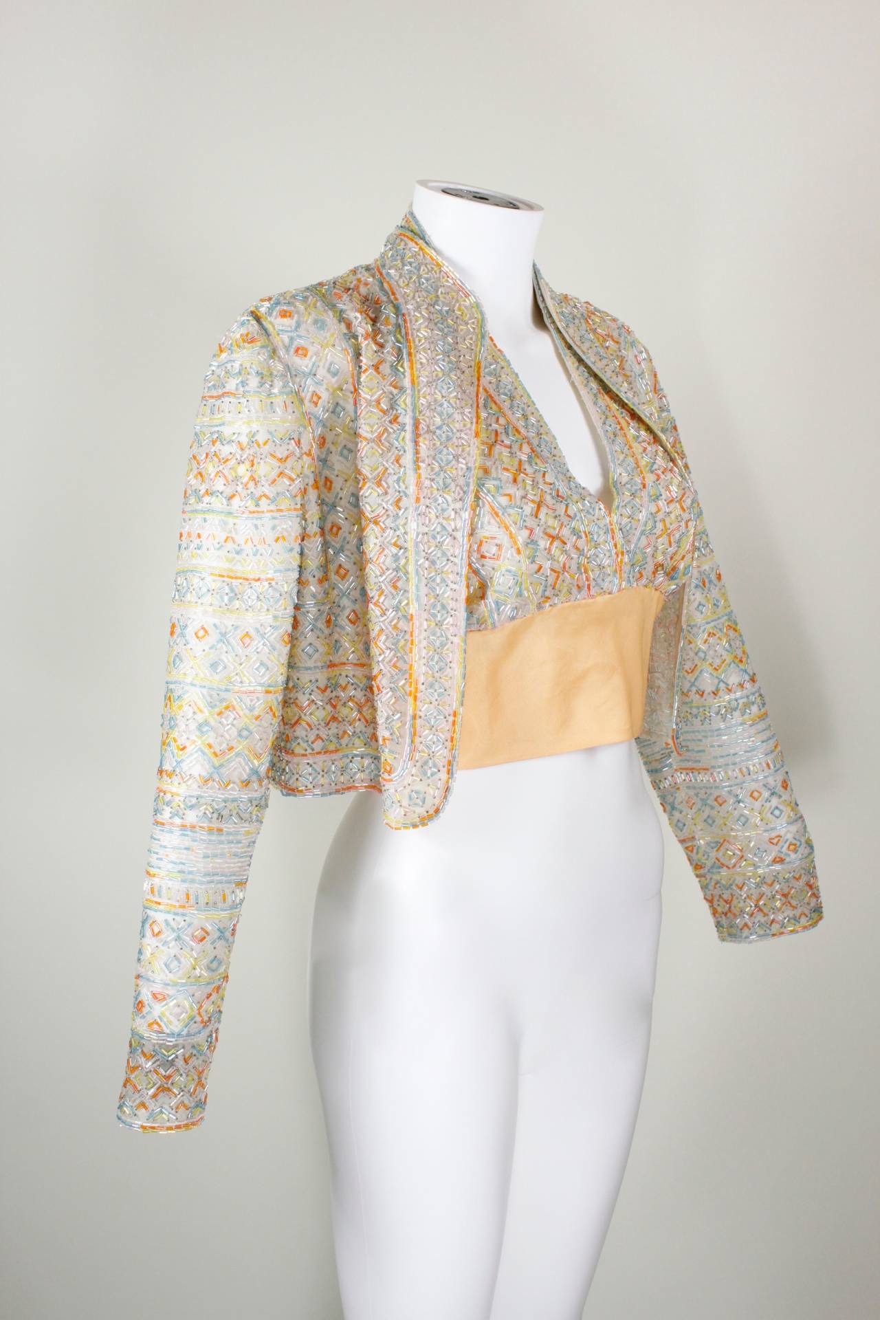 A gorgeous halter top and jacket ensemble, likely Halston. Vibrant orange, yellow, blue, light pink bugle beads are sewn onto cream organza. The halter top features a sherbert orange waist and tie in the back (please note, there is no tie or hooks
