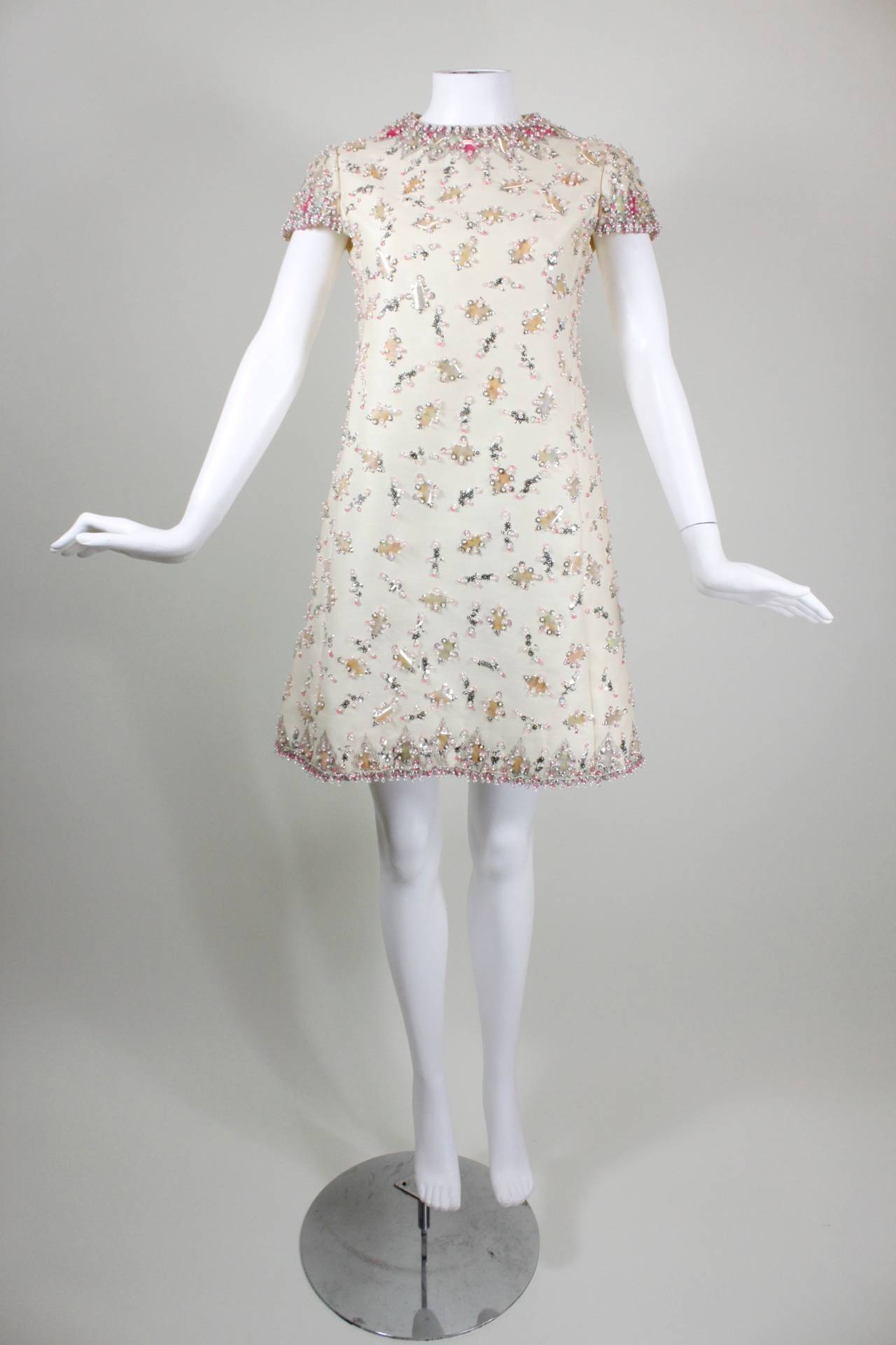 1960s Malcolm Starr Cream Party Dress with Blush Paillettes

-Silver metallic geometric embroidery at neckline and hem
-Clear iridescent and vibrant pink paillettes throughout
-Light pink, bright pink, and pearl beading at the neckline
-Silver