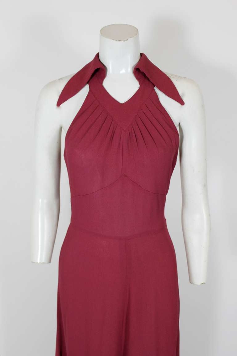 An iconic 1970s Gown from Ossie Clark, done in a luxe plum crepe. Gown is in the style of 1930s bias cut gowns, and accented with a large collar and deep-v neck.

-Center back zip

Measurements--
Bust:  34 inches
Waist:  28 inches
Hip:  up to