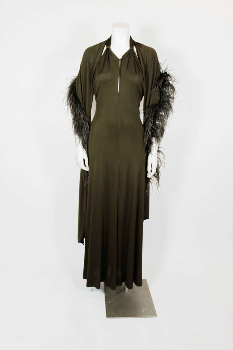 An incredibly sexy halter gown from the master of slinky jersey, Halston. The gown has a knotted halter collar and subtle deep neckline; it is also paired with a fabulous ostrich-feather trimmed jersey wrap.

Measurements--
Bust: 36