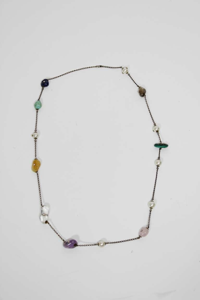 A gorgeous necklace from CHANEL. Composed of Chanel costume pearl, amethyst, rock crystal, rose quartz, malachite, and turquoise; the stones are embedded with delicate tube-set rhinestones. 

Chain is about 36 inches in total; hangs approximately