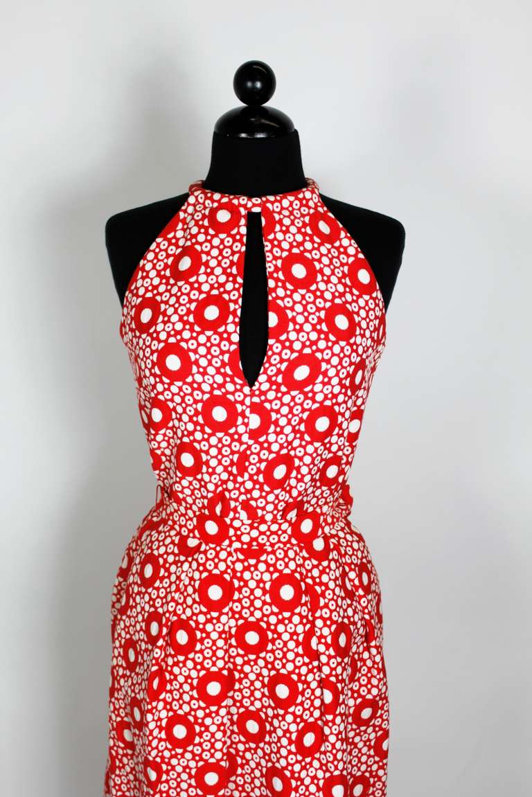 A fabulous ensemble from iconic 1960s designer Pierre Cardin. Done in a bold, graphic red and white dot pattern. Halter top snaps at neck and zips in back. Skirt zips in back and has high slits up the side with a rounded hem.

-Blouse zips in