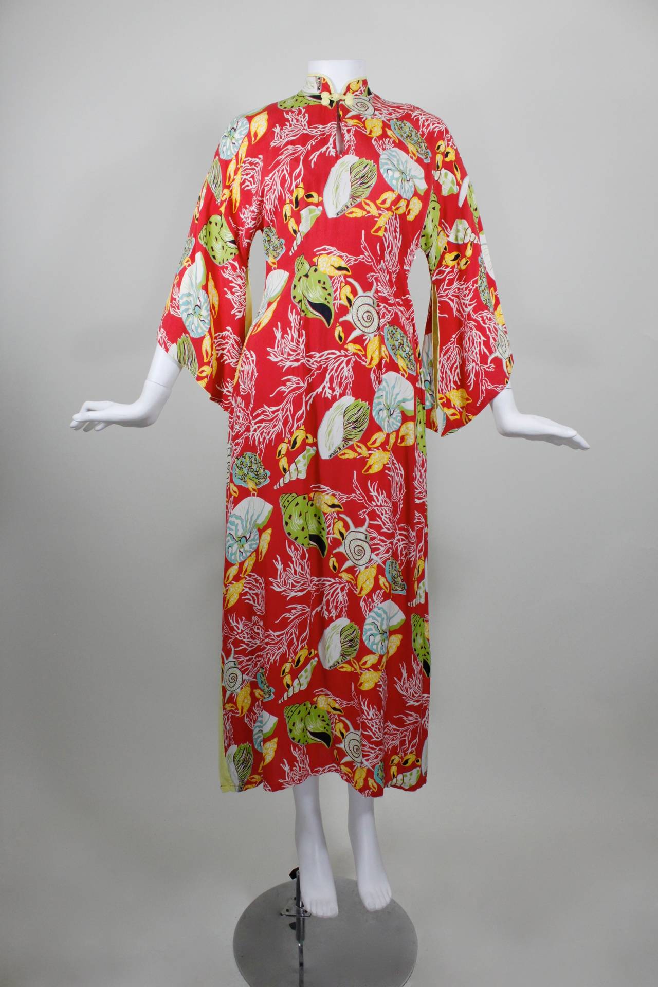 This 1940s Hawaiian rayon gown features a wonderful, bold aquatic print in the most fabulous and vibrant colors. A variety of large-scale shells pop against a red background.

-Fully lined
-Side zip
-Minimal color
