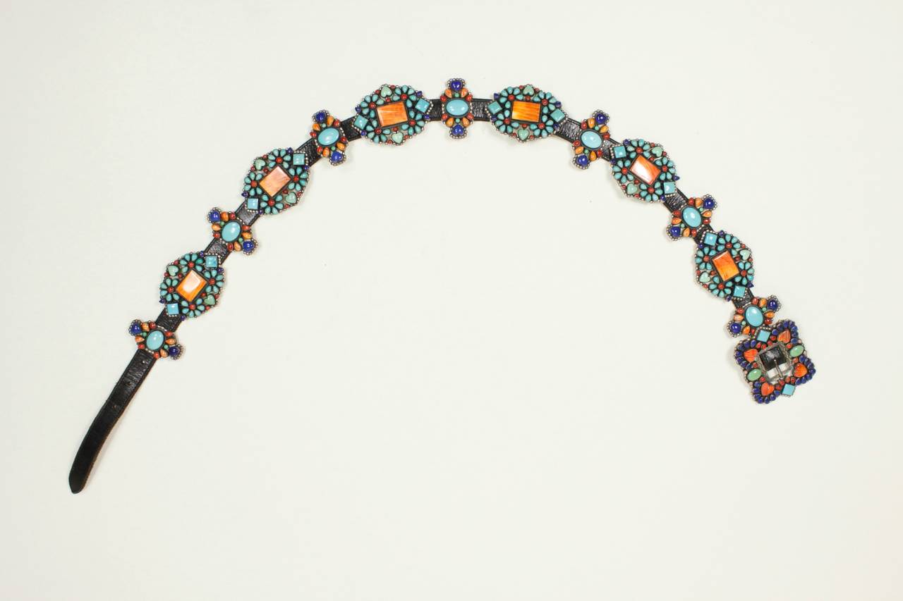 A wonderful Native American-Inspired belt, featuring spiny oyster shell (orange), coral (red), turquoise, and lapis set in sterling silver conchos and butterflies. The design features a floral motif with heart-shaped turquoise throughout, as well as