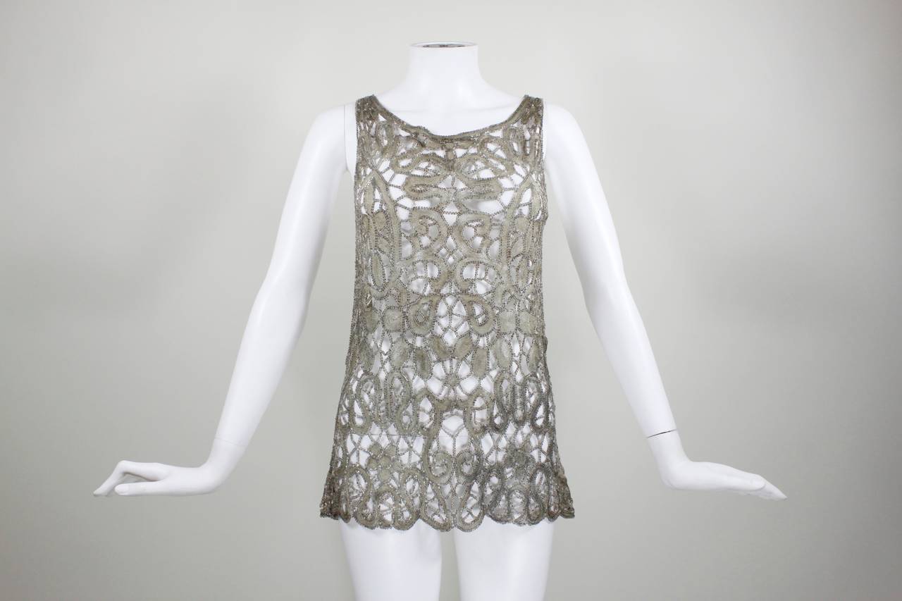 This is a truly stunning lace cutout blouse from the 1920s. Gold metallic embroidery is done on nude net and finished with smokey, small bugle beads throughout.

Measurements--
Bust: 36 inches
Waist: 32 inches
Hip: up to 40 inches
Length,