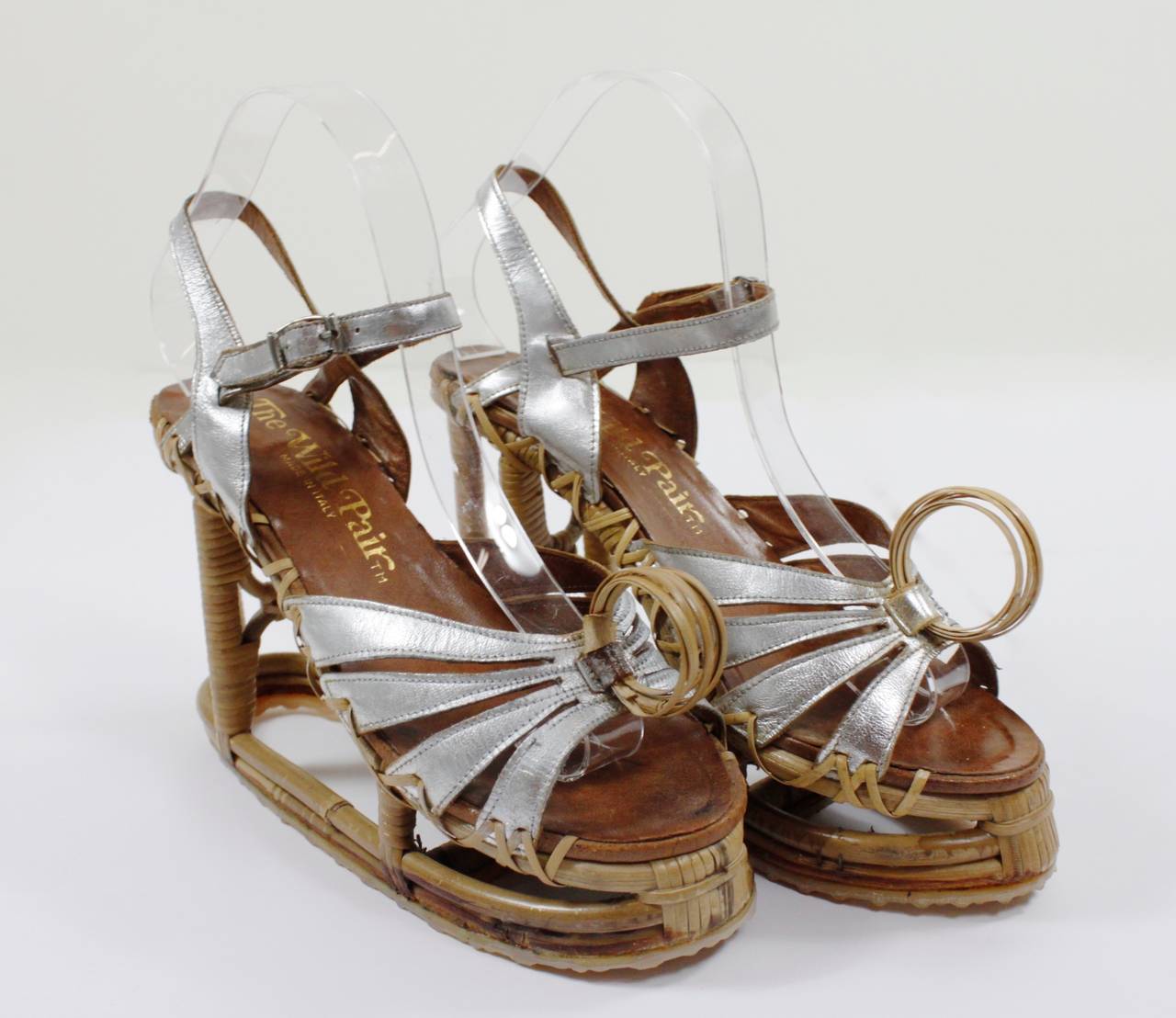 A fabulous pair of reed and leather wedges. The scaffolding-like reed wrapped pillars create a dynamic wedge heel with silver metallic straps.

Heel Height: 5 inches
Shoes Size: 6