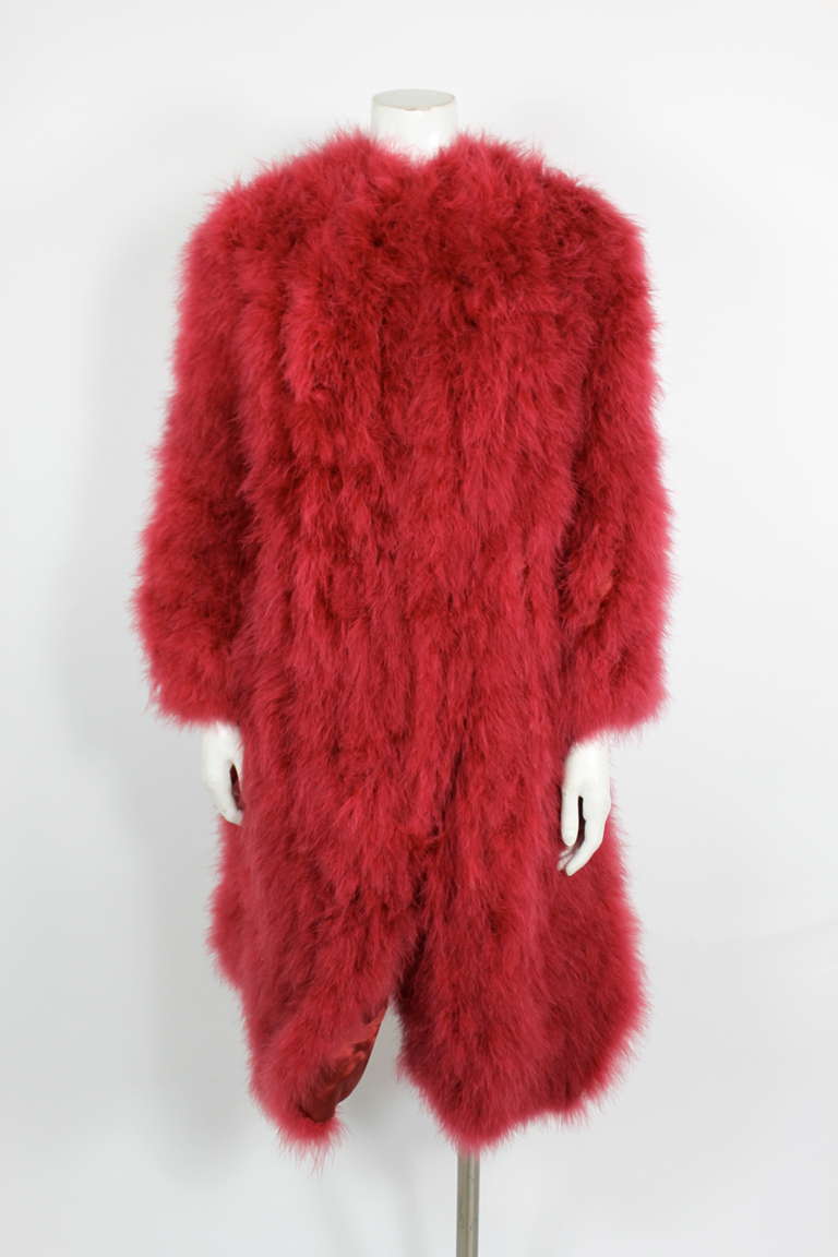 A fab strawberry pink marabou coat. The coat fastens with hooks and eyes down the front and lands at mid-thigh. Fully lined.

Measurements--
Sleeve Length: 25 inches
Length, Shoulder to Hem:  41 inches
Bust:  30 inches