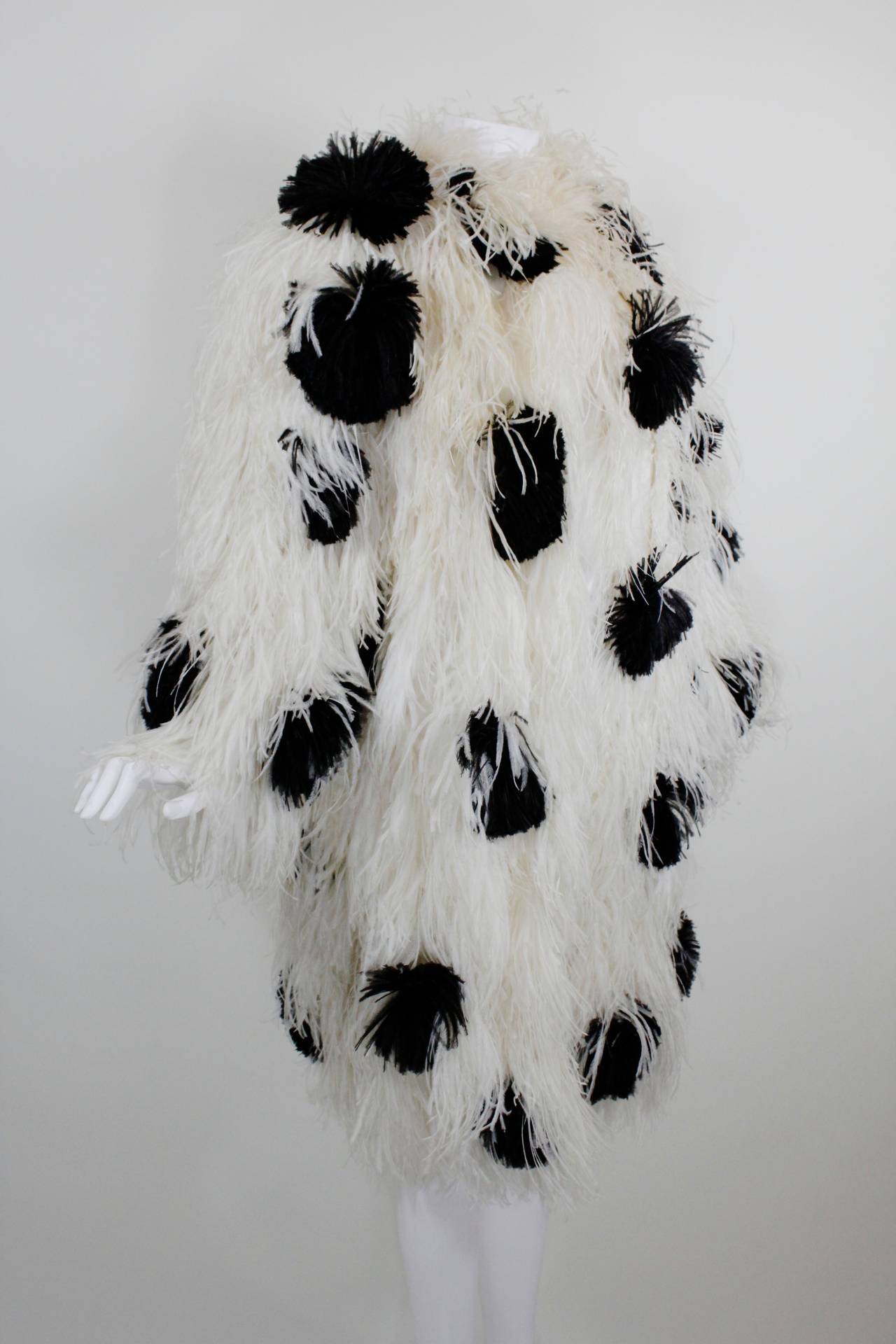 A fabulous ostrich feather coat from Bill Blass featuring snow white feathers dotted with black plumes throughout. The coat is fully lined and has a hook-and-closure at the neck.

Measurements--
Bust: 44 inches
Waist: 44 inches
Hip: 44