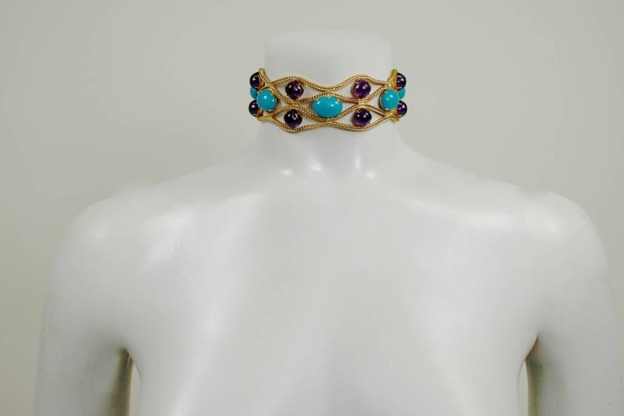 A fabulous choker necklace from famed costume jeweler Kenneth Jay Lane. The gold tone chain is accented by opaque turquoise glass stones and tranlucent purple glass stones. It can easily be worn as evening jewelry, or to accessorize a simple white
