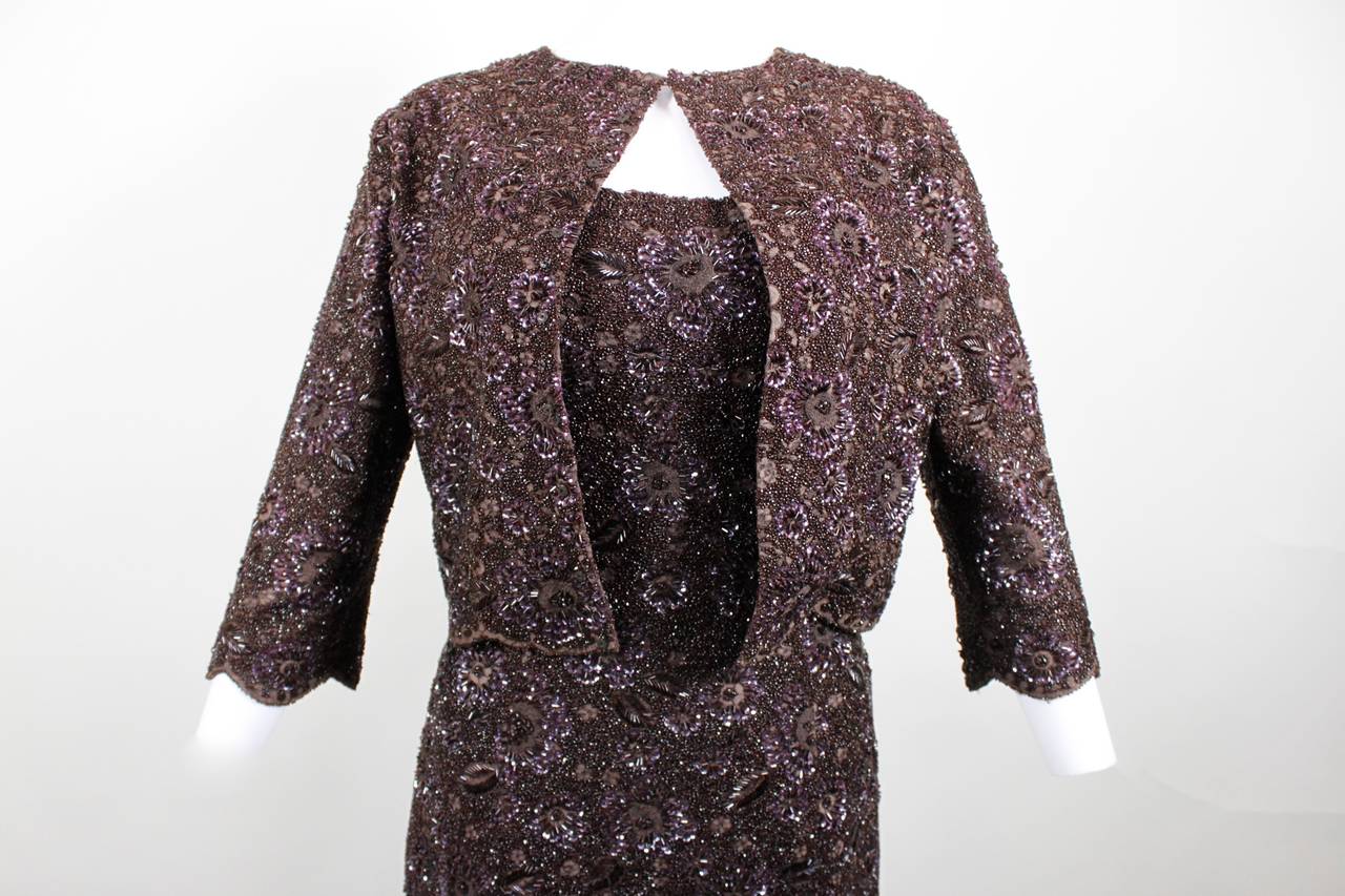 This is an incredibly stunning evening gown and matching jacket from Mingolini Guggeheim. A strapless a-line evening gown is done in rich mocha brown lace, heavily hand-beaded and sequined throughout with a scalloped hem. A horsehair lining