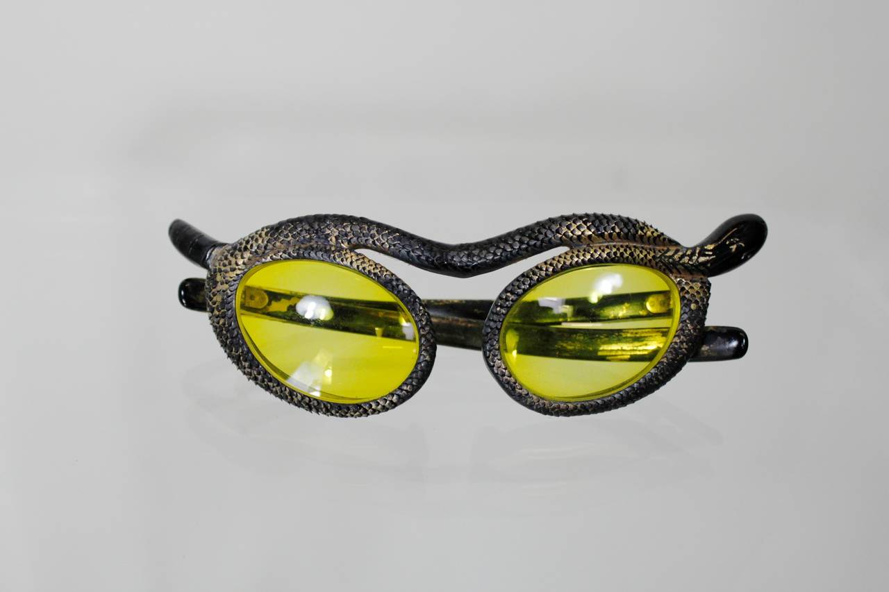 A super rare pair of snake sunglasses from designer Paulette Guinet. The cat-eye frames feature a carved, scaled snake wrapping around the eye.

-Very good vintage condition. Gold leaf paint has worn throughout.
-Prescription lenses.