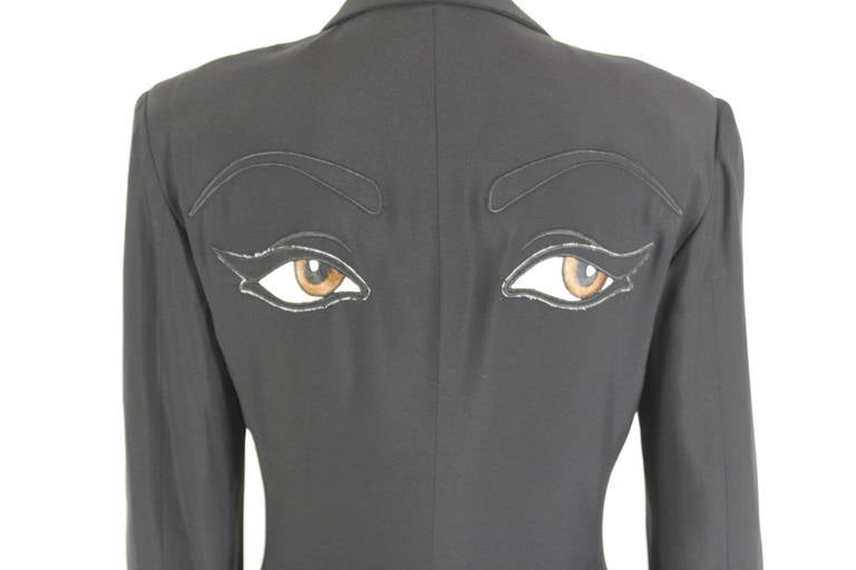 A beautifully constructed black blazer from Moschino Couture. The single-breasted jacket is luxe, tailored, and has the whimsical surprise of embroidered eyes on the back.
-Fully lined
 
Measurements--          
Bust:  36
