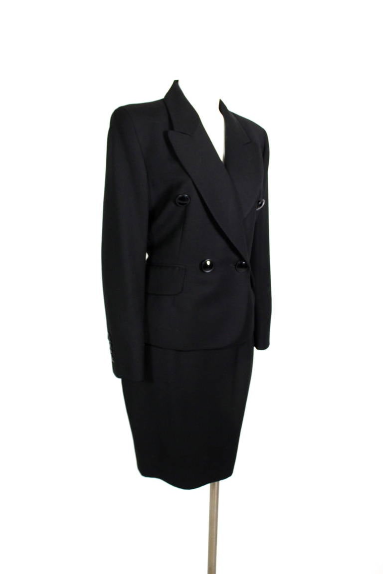 At once a luxurious wool suit and an ensemble with a sense of humor, this Moschino Couture piece is chic, cool, and fun. The double breasted jacket and wool pencil skirt are beautiful constructed and ultra wearable. Fully lined. Skirt zips in back.