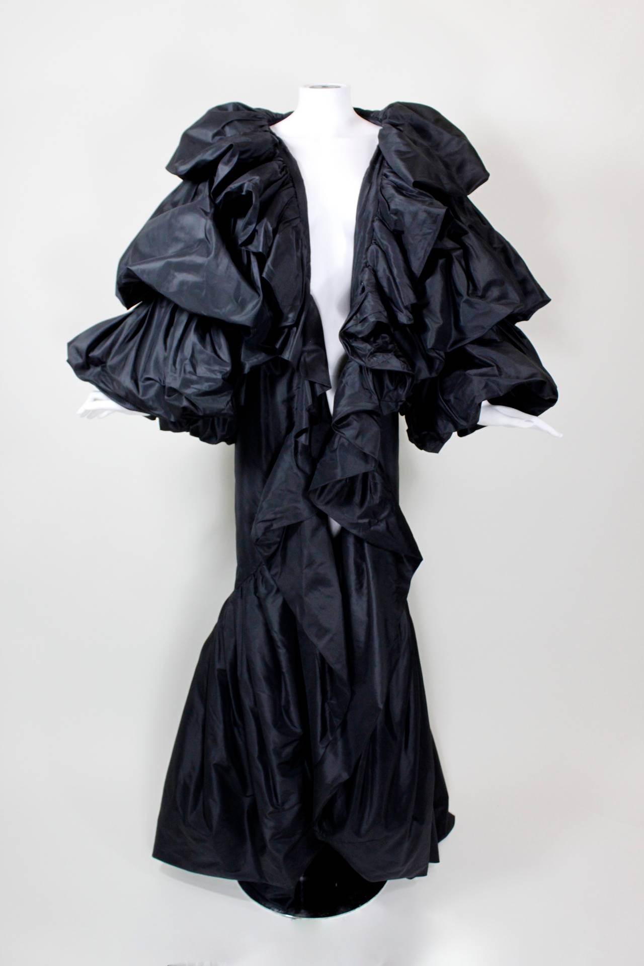 A fabulous, full-length statement evening coat, done in tiered, billowing taffeta. Attributed to Bellville Sassoon.

This cape would best fit a US 2 or 4.

Measurements--
Bust: 34 inches
Waist: free
Hip: free