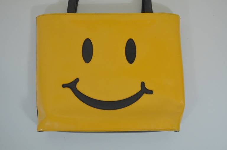 An iconic smiley face totebag from 90s Moschino. Always utilizing pop iconography of the time, Moschino chronicled the culture of fashion in his creations. 

Width: 15