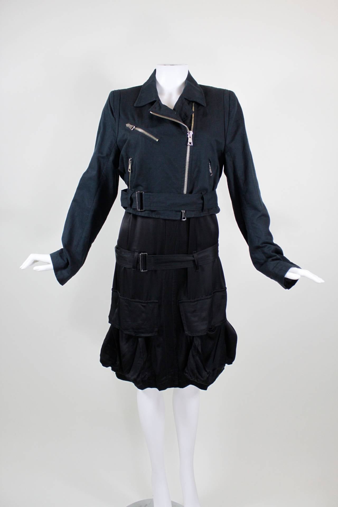 A longline moto jacket from Ann Demeulemeester, featuring a traditional cotton/linen bodice with a rayon tail. The jacket also has two large, functional rayon cargo pockets on front, and an adjustable waist belt and hip belt. Both belts button in