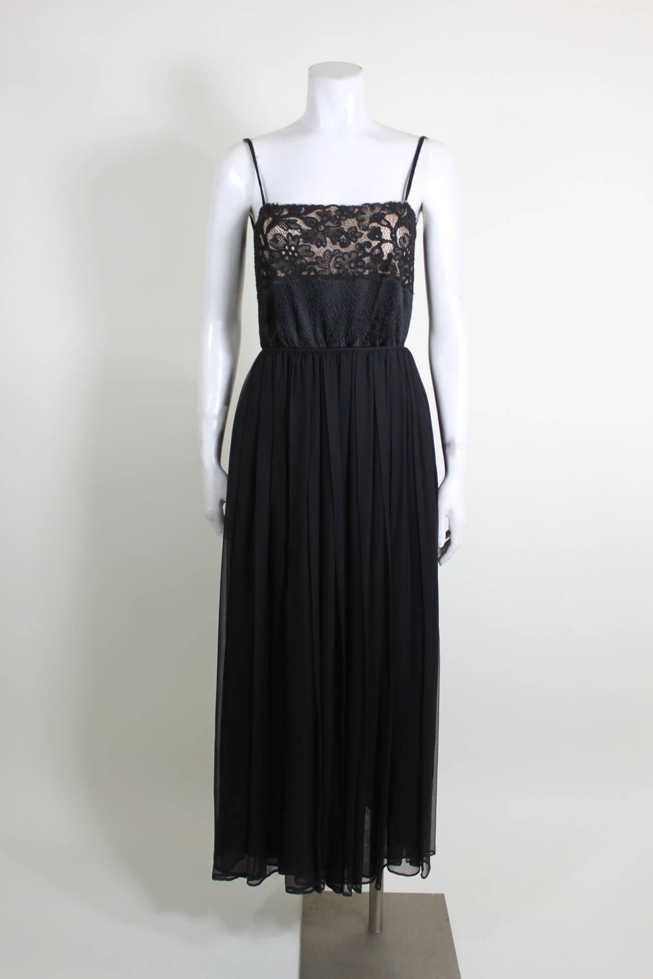 An ultra sexy evening gown from Galanos done in silk. Featuring a black lace on nude bodice, the skirt is made of luxe flowing chiffon. The back is cut low and ties. Zipper back closure. 
