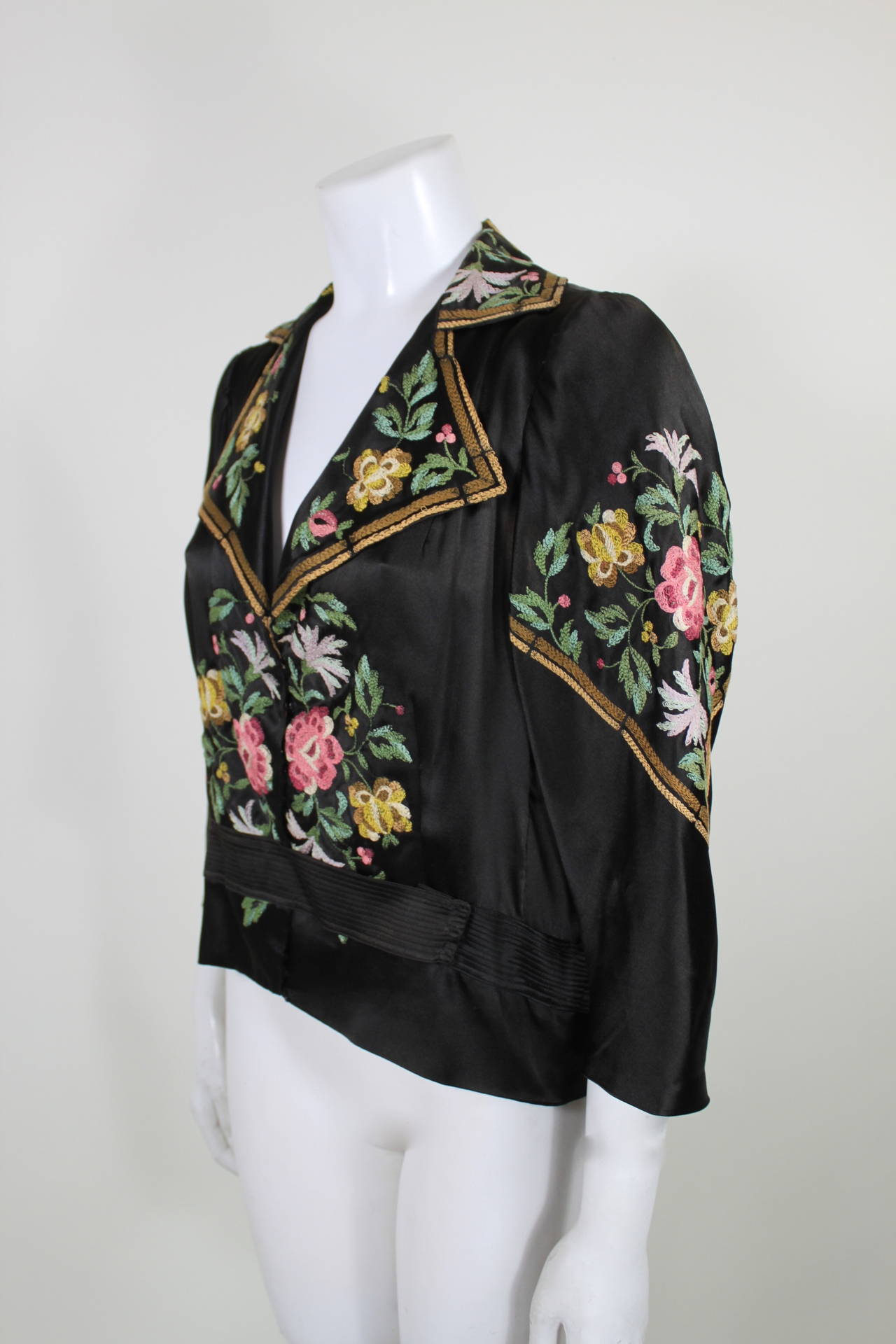 A gorgeous blouse from the 1920s. Done in a luxurious black silk, the blouse has beautiful, colorful floral embroidery throughout. Construction of the blouse includes weights throughout to maintain shape and fit.

-Unlined
-Slight fade under