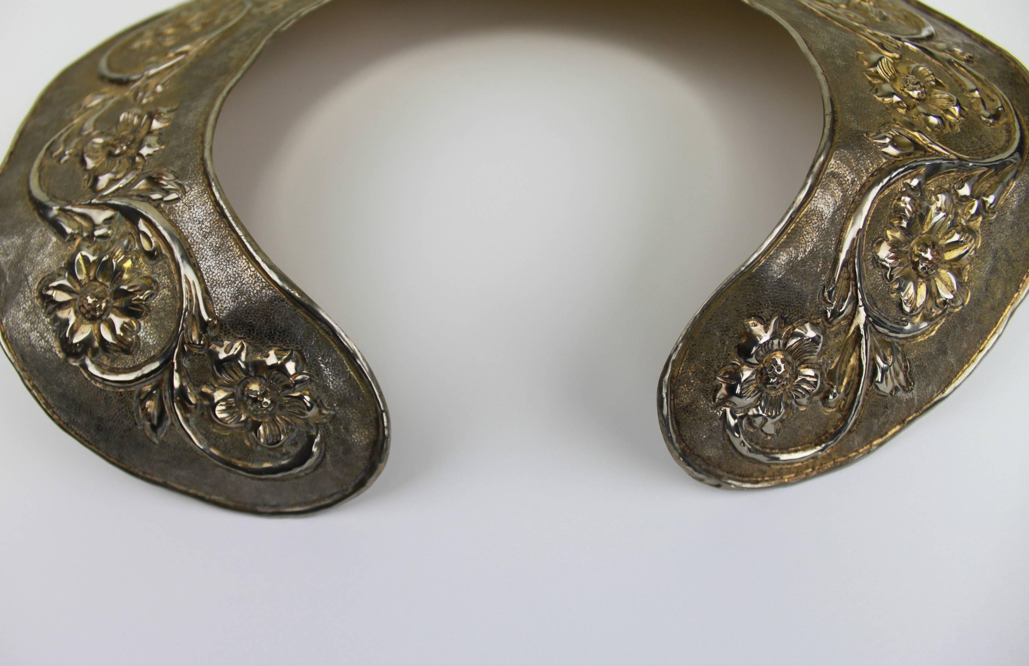 A fabulous Heraldic motif collar from the 1970s, featuring a repoussé technique. The collar is slightly adjustable, and would accent a high-neck blouse or gown, but is incredibly striking on its own. 

-Herald motif
-16 inches around interior