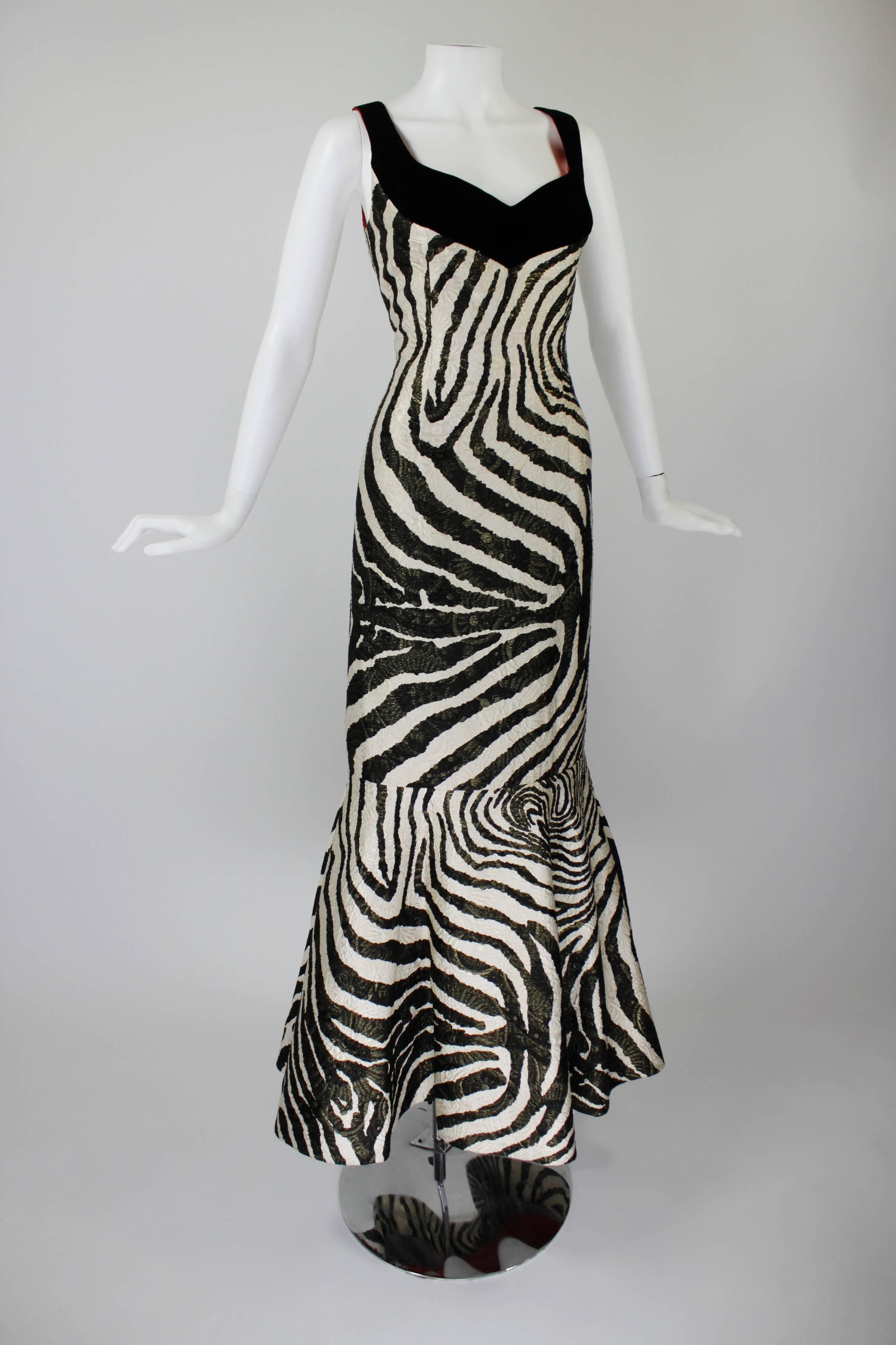 A fabulous, sexy evening gown from Arnold Scaasi. Done in a bold, metallic zebra print, the hourglass silhouette flares into a fishtail at the hem. A matching triangle-shaped, fringe-border wrap accompanies the gown.

-Fully lined
-Zips in