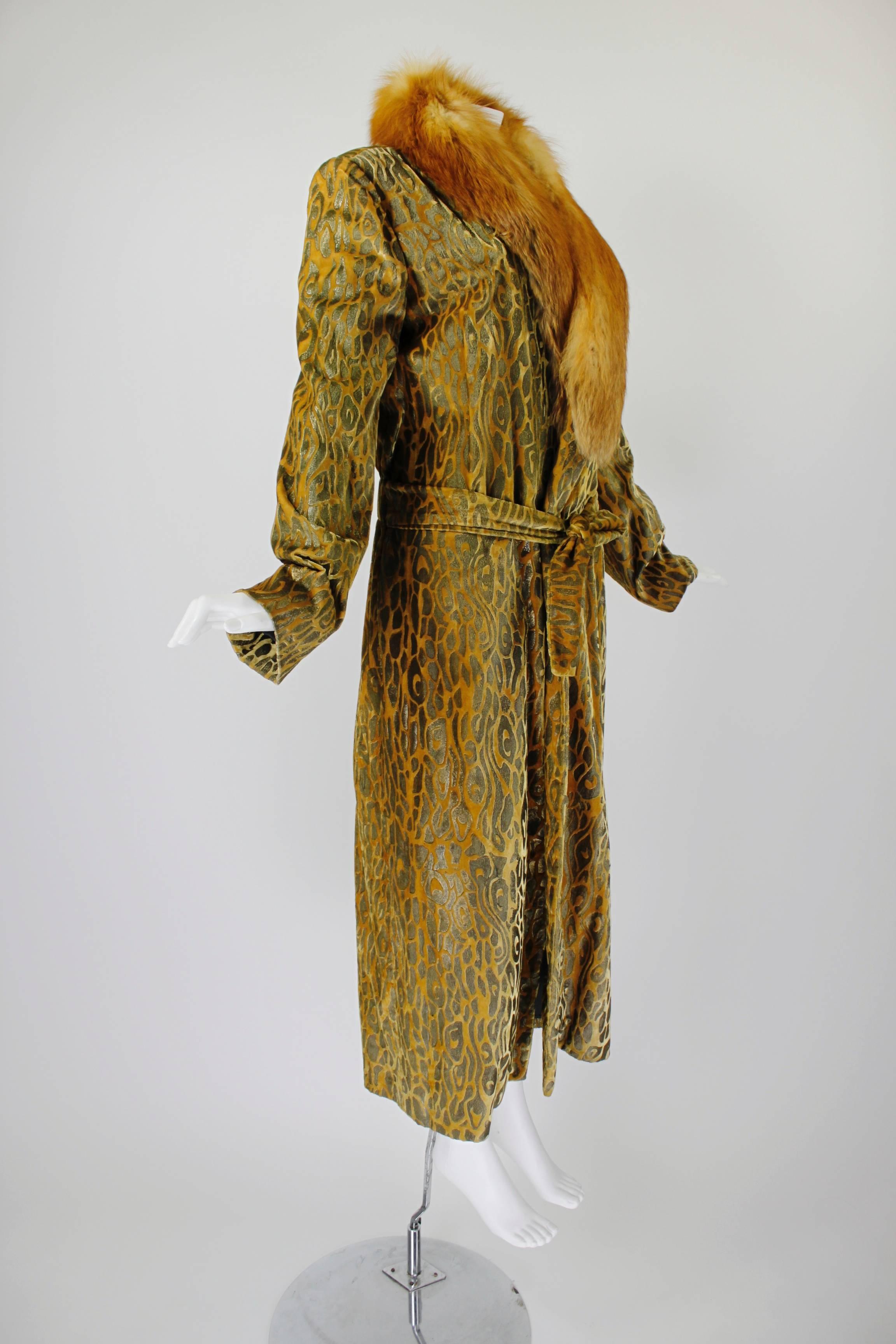This fabulous Bill Blass opera coat is done in a gorgeous marigold paisley velvet with blonde fox fur trim. The drop waist is gathered/elasticized and features an attached belt.

-Fully lined
-Tie-belt closure
-Fur is