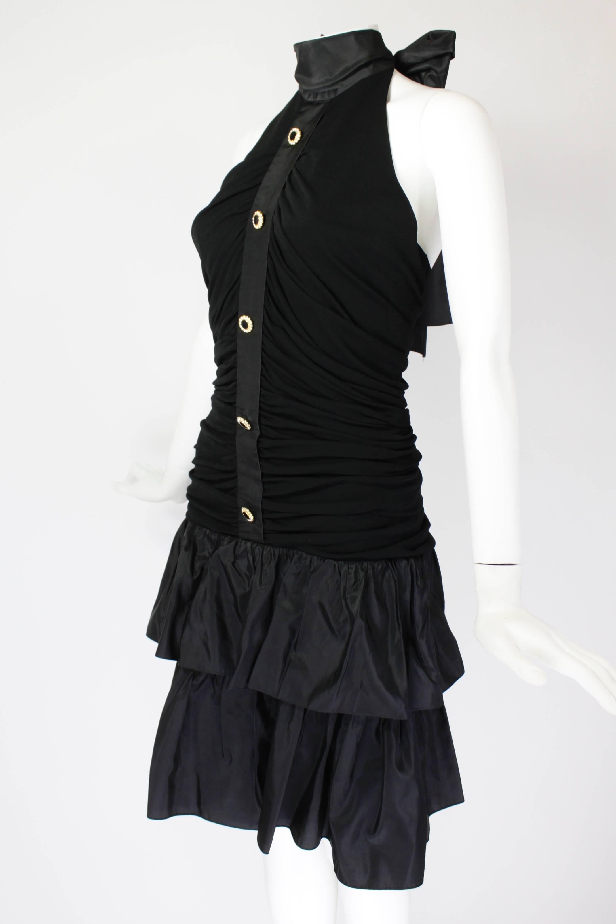 A black jersey party minidress from Givenchy, featuring a taffeta halter top, and rhinestone enamel buttons down the front. 

-Fully lined
-Zips in back

Measurements--
Bust: 32 inches
Waist: 26 inches
Hip: 34 inches
Length, Center Back to