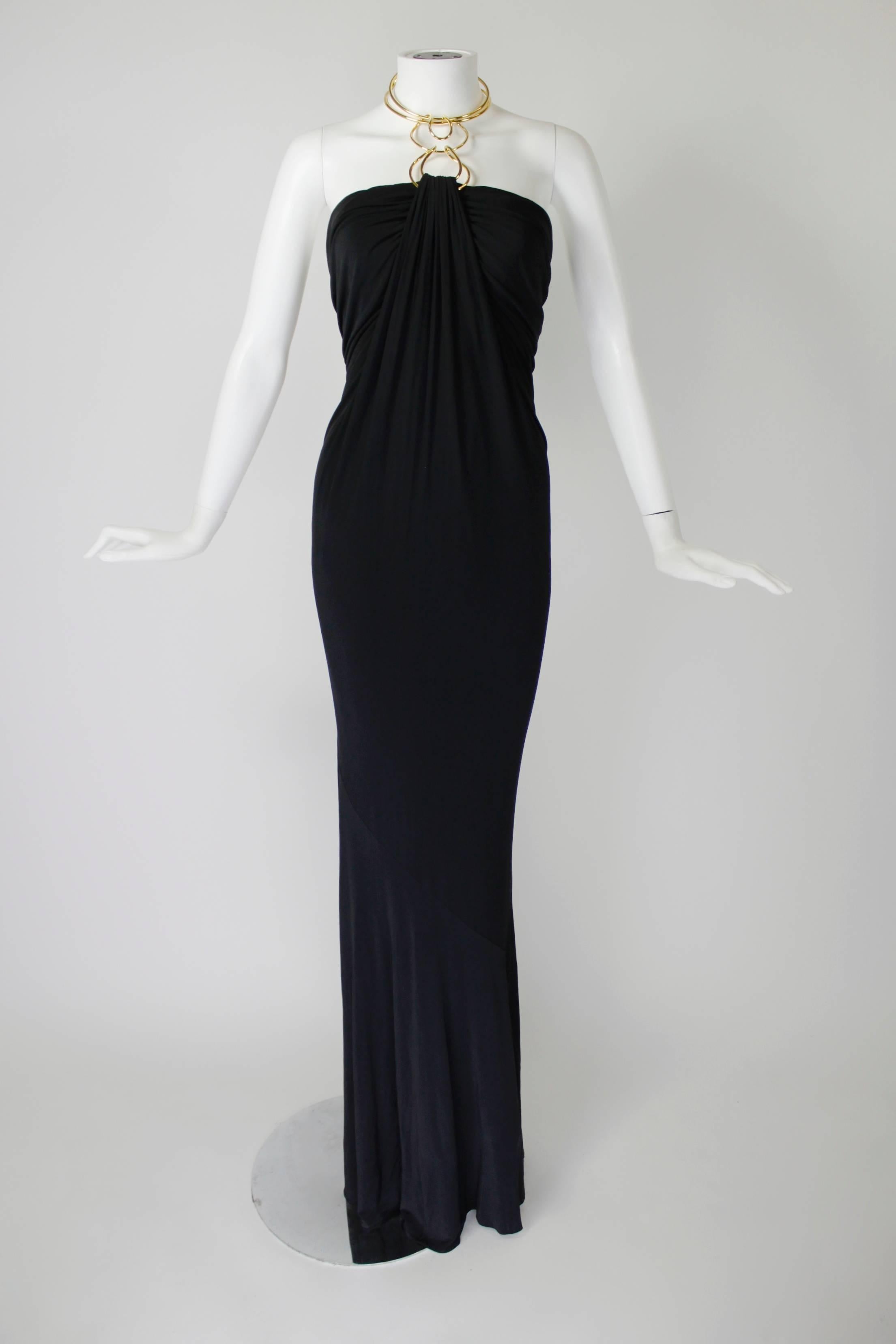 An insanely sexy, slinky jersey evening gown from Donna Karan. The halter neck is gathered by interlocking gold-tone metal loops, creating a collar necklace.

Marked a size Medium.

Measurements--
Bust: 32 inches, relaxed; stretches up to 38